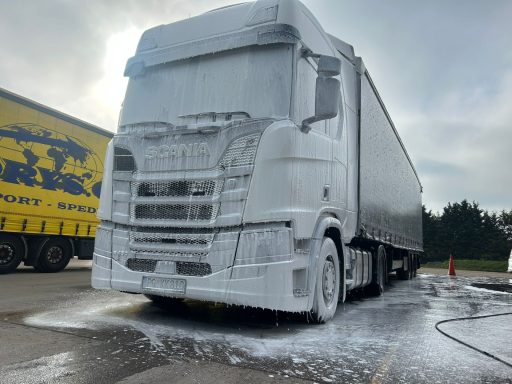 Truck covered in cleaning foam during the wash process